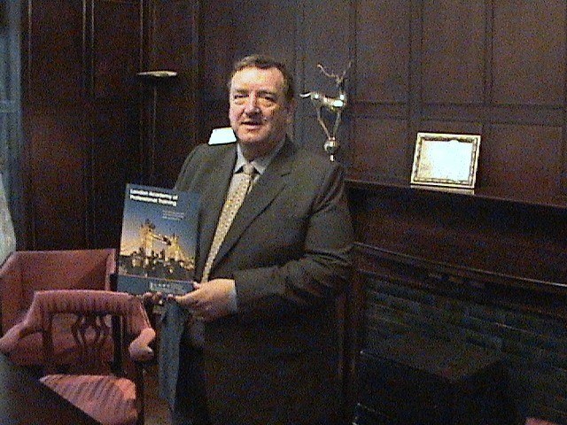 Dr Desmond Adair, Chairman of LAPT, holding the London Academy of Professional Training prospectus at the office at 29 Harley Street, London